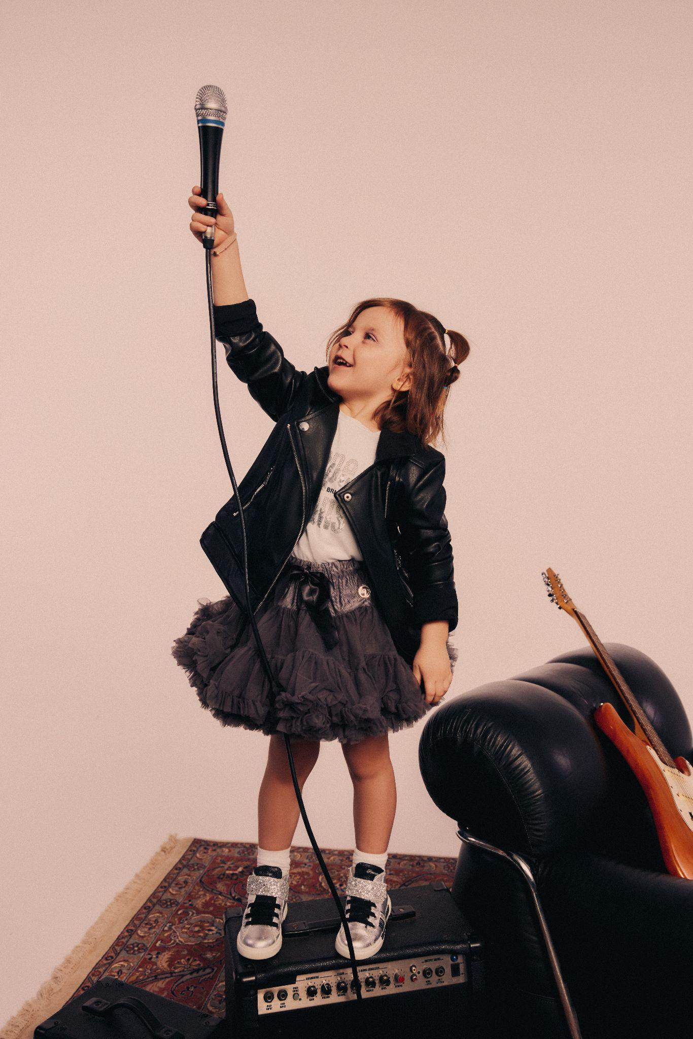 dziewczynka w rockowej stylizacji trzymająca mikrofon