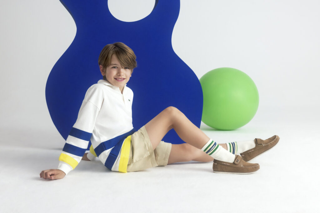 chłopiec w bluzie dziecięcej typu polo, szortach i sneakersach