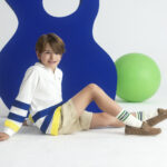 chłopiec w bluzie dziecięcej typu polo, szortach i sneakersach