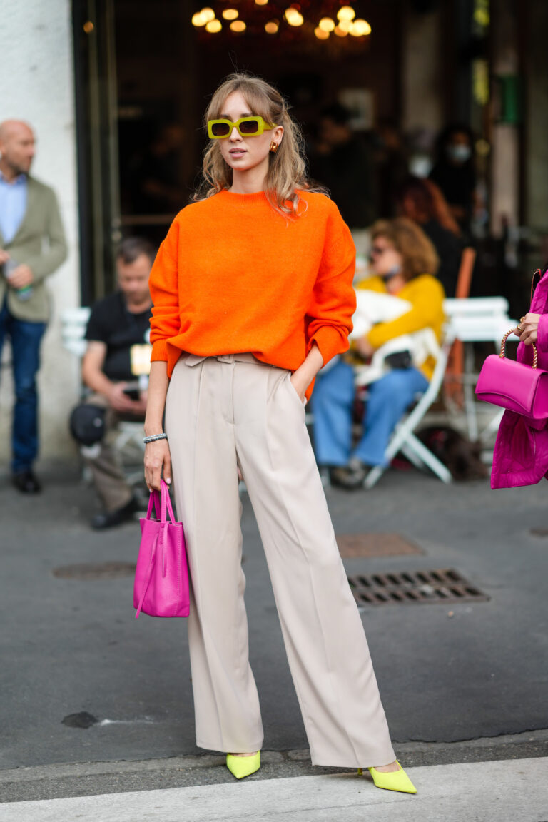 Moteris, dėvinti plačias kelnes ir smailianosius, citrinų spalvos batelius