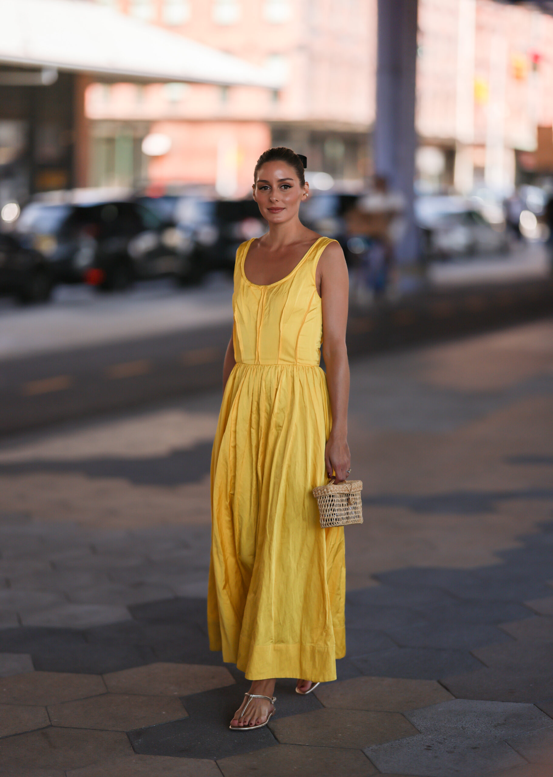 Femme en robe maxi jaune et des sandales argentées