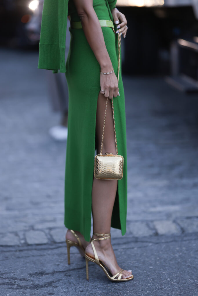 długa zielona sukienka w połączeniu ze złotymi szpilkami i torebką