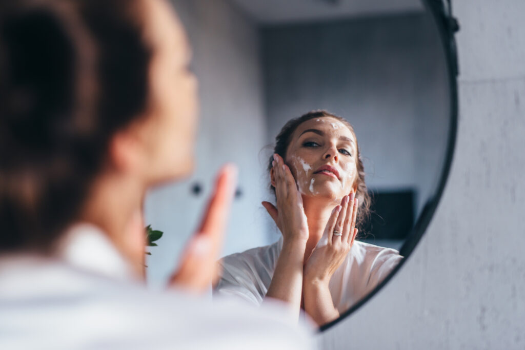 kobieta myjąca twarz przed lustrem